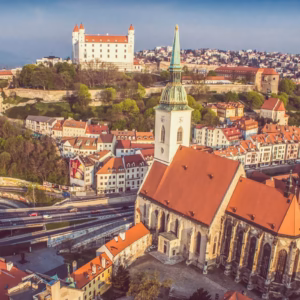 Aerial view of Bratislava Old Town showcasing St. Martin's Cathedral in the foreground and Bratislava Castle on the hill near Skaritz Hotel.