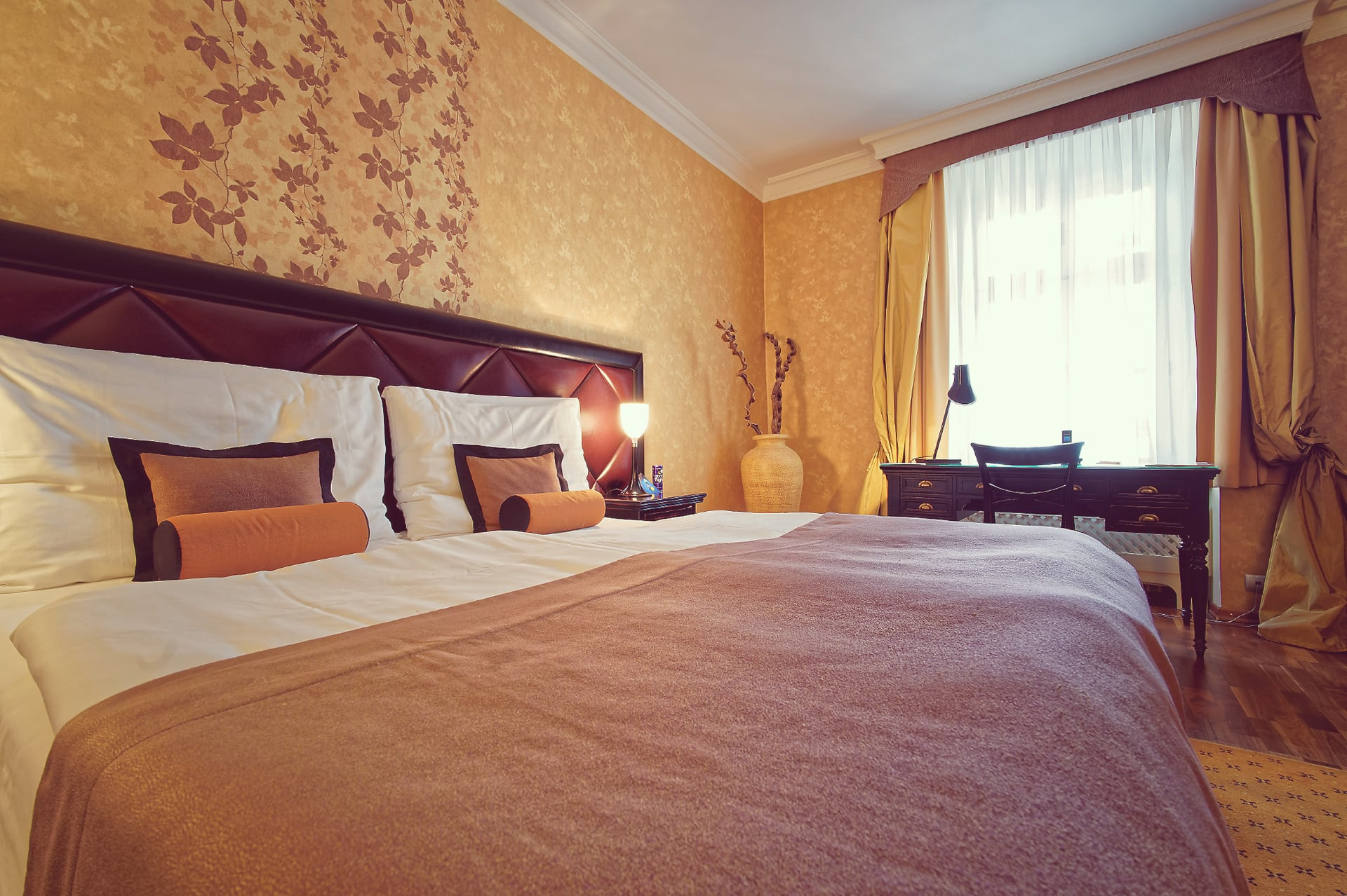 Close-up of bedding and pillows in a single room with desk and window in background at SKARITZ Hotel Bratislava