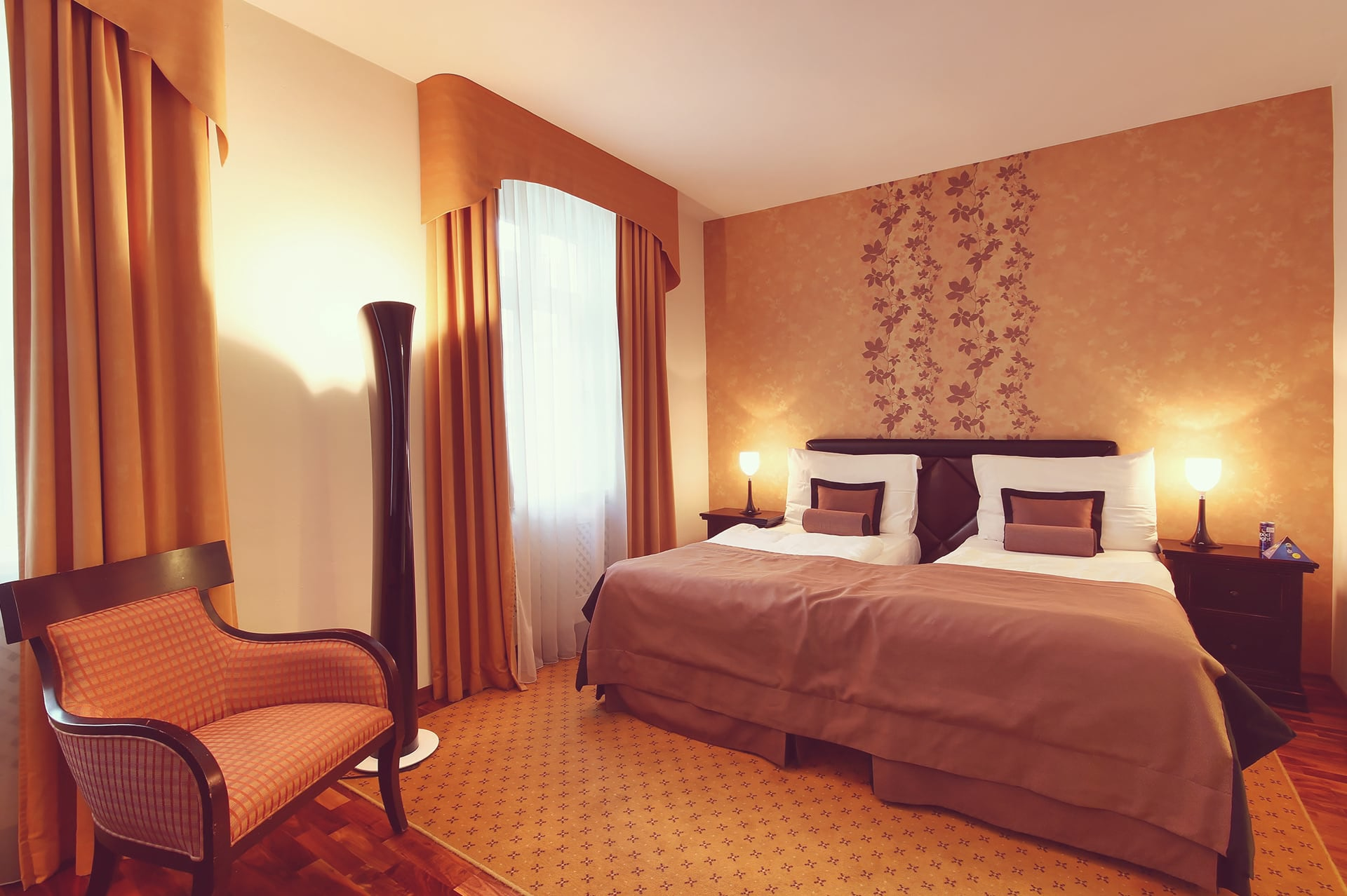 Bed with leather headboard and lounge chair in a single room at SKARITZ Hotel Bratislava